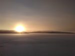sun set behond frozen lake