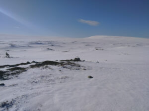 mostly snow covered fell landscape with some soil already visible