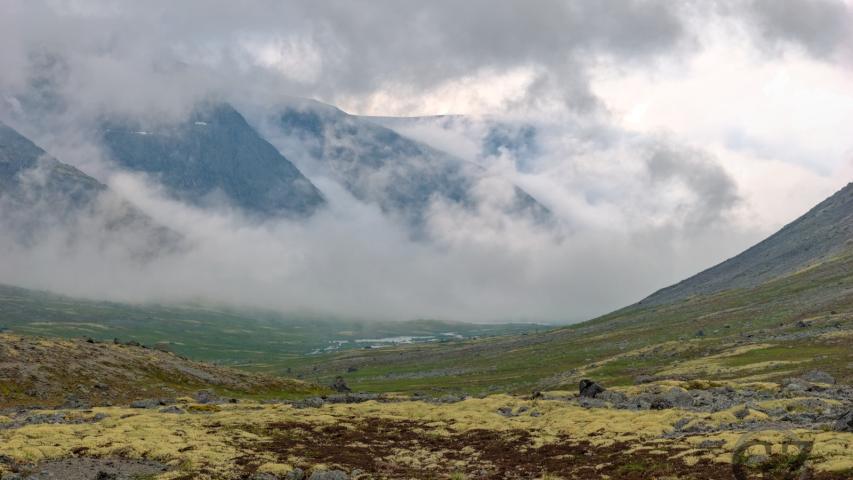 fog creeping up steep mountain slopes